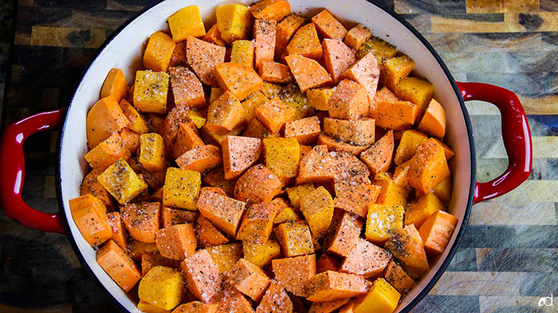 adding salt and pepper to sweet potatoes and butternut squash